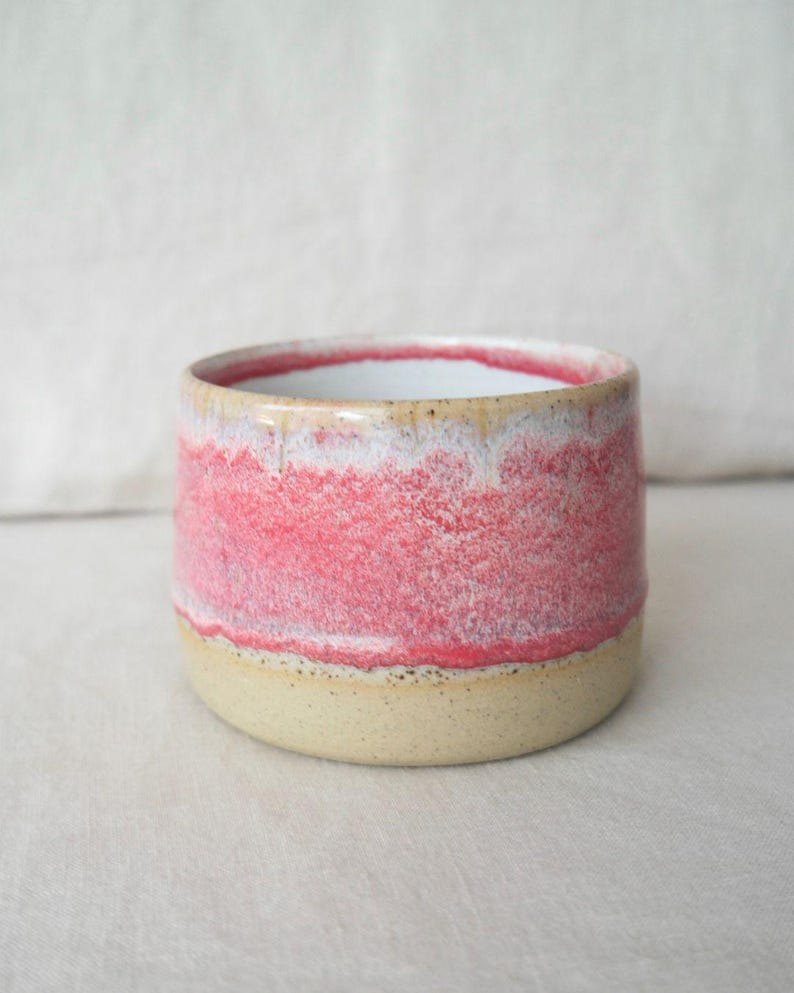 Wheel thrown pottery coffee cup in soft pink tones with lava glaze. Handmade ceramic handleless mug, dishwasher safe, unique drinkware gift.