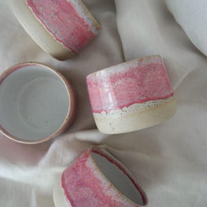 Handmade ceramic pink pottery cup, crafted in Australia with glossy glaze. Wheel thrown handleless mug, dishwasher safe, perfect gift for coffee and tea drinkers.