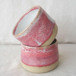 Pink pottery tea cup with glossy glaze finish. Wheel thrown ceramic handleless mug, dishwasher safe, food safe and gift wrapped. Artisan handmade pottery cup perfect for gifting or everyday use.