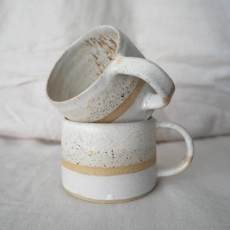 Unique handmade pottery mug, rustic design, wheel thrown with natural clay, perfect for coffee or tea.