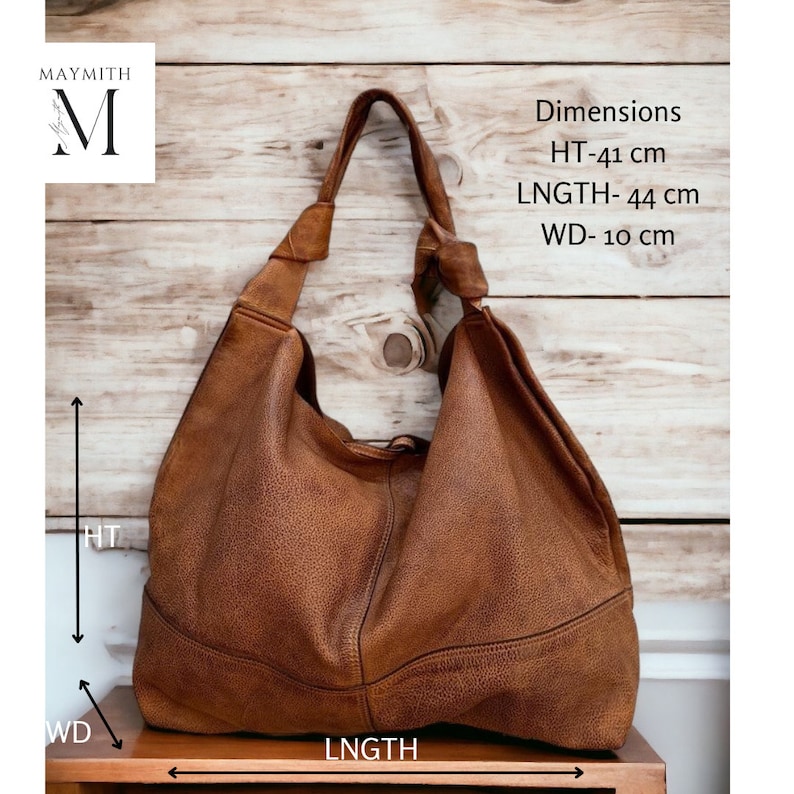 May include: A brown leather shoulder bag with a knotted strap. The bag is 16 inches high, 17 inches long, and 4 inches wide. The bag has a textured surface and is displayed against a wooden background. The brand name "MAYMITH" is in the upper left corner.