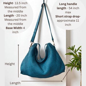 K&ouml;nnte beinhalten: Eine teal gewebte Handtasche mit einem langen, verstellbaren Riemen und einem k&uuml;rzeren Riemen. Die Tasche ist etwa 34 cm hoch, 51 cm lang und 10 cm breit an der Basis. Der lange Griff ist 137 cm lang, und der kurze Riemen hat eine Tiefe von etwa 28 cm.