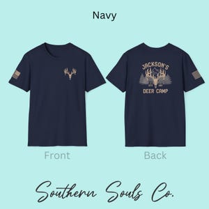 May include: Navy blue t-shirt with a deer antler graphic on the front and a matching design on the back that reads "Jackson's Deer Camp Est. 1964". The shirt also features a small American flag design on the sleeve. The text "Southern Souls Co." is at the bottom.