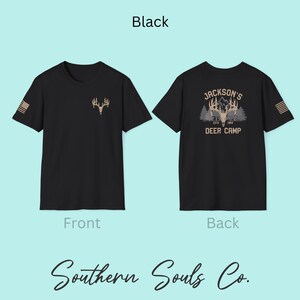 May include: Black t-shirt with a deer antler graphic on the front and a small American flag on the sleeve. The back of the shirt features a deer camp design with the text "Jackson's Deer Camp ESTD 1984". The text "Southern Souls Co." is at the bottom.
