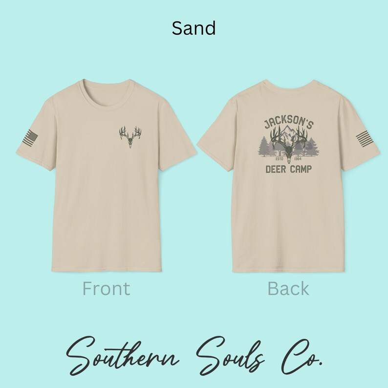 May include: Sand-colored t-shirt with a deer antler graphic on the front and a "Jackson's Deer Camp" design on the back. The shirt includes the text "Southern Souls Co." and an American flag design on the sleeve.