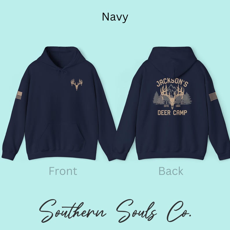 May include: Navy blue hoodie with a deer antler graphic on the front and back. The back of the hoodie features the text "Jackson's Deer Camp Estd 1964". The front of the hoodie has a small deer antler graphic. The text "Navy" is at the top.