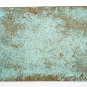 Puede incluir: Una lámina de metal rectangular que presenta una superficie desgastada y oxidada con una textura moteada. El acabado muestra una mezcla de tonos turquesa claro, verde azulado y marrón tierra, creando un aspecto envejecido en la superficie.