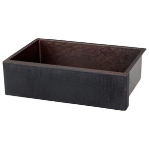 May include: A farmhouse style copper kitchen sink with a hammered finish. The sink is black on the outside and copper on the inside.