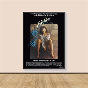 May include: A movie poster for the film Flashdance, featuring a woman in a white shirt and red shoes sitting on a chair. The poster has the text "Flashdance" in blue and white letters, and the tagline "Something happens when she hears the music... It's her freedom. It's her fire. It's her life." in black text.
