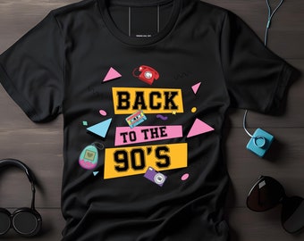 Op de afbeelding: Zwart T-shirt met een geel, roze en blauw grafisch ontwerp. De grafiek bevat de tekst "Back to the 90's" met retro-iconen zoals een cassettebandje, een telefoon en een Tamagotchi.