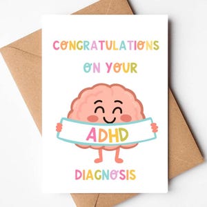 May include: A white greeting card with the words "CONGRATULATIONS ON YOUR" in colourful letters. A cartoon brain holds a banner that says "ADHD" and the word "DIAGNOSIS" is at the bottom. The card is inside a brown envelope.