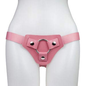 May include: Pink leather harness with a silver metal ring and two adjustable straps.