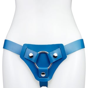 May include: A bright blue leather harness belt featuring a central silver-toned metal ring. The design includes three leather straps secured to the ring with polished silver-toned metal rivets, creating a geometric front-facing structure.