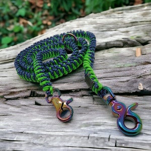 May include: A green and black paracord dog leash with two iridescent metal clips.