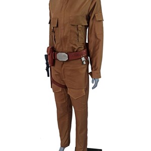 May include: A brown jumpsuit with a brown belt and a silver buckle. The jumpsuit has a collared shirt with a mandarin collar and long sleeves. The jumpsuit has two pockets on the chest and two pockets on the legs. The jumpsuit is worn by a mannequin.