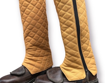 May include: A pair of brown leather boots with quilted yellow gaiters. The gaiters have a black zipper on the side and a strap with a buckle.