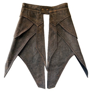 May include: A brown leather skirt with a high waist and a split front. The skirt has a geometric design with pointed edges.
