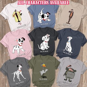 Op de afbeelding: Een set van negen T-shirts met verschillende personages uit de Disney-film 101 Dalmatiërs. De personages omvatten Cruella de Vil, Dalmatiër-pups en de schurken Horace en Jasper. Elk shirt heeft een ander personage en een ruimte voor een naam.