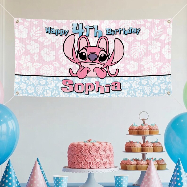 Op de afbeelding: Een roze en witte banner met de tekst "Happy 4th Birthday Sophia" en een stripfiguur. De banner is versierd met een bloemenpatroon en een blauwe rand. Een roze taart en cupcakes worden tentoongesteld.