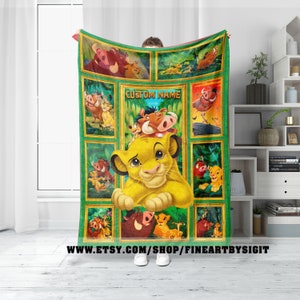 May include: A green and gold fleece blanket with a collage of images from the Disney movie The Lion King. The blanket features Simba, Pumbaa, Timon, and other characters from the movie. The text "CUSTOM NAME" is printed in the center of the blanket.