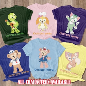 May include: A collection of six colorful t-shirts featuring cartoon characters. Each shirt displays a different character, including a turtle, a dog, a cat, and a bear. The text "Custom name" appears on each shirt, with the words "ALL CHARACTERS AVAILABLE" at the bottom.