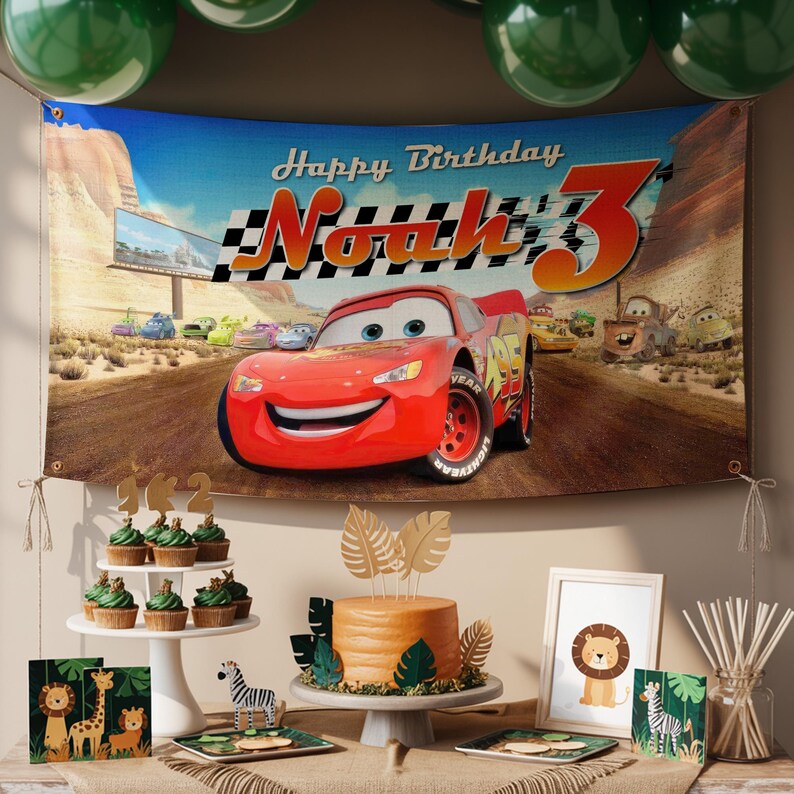 May include: A birthday party scene featuring a banner with Lightning McQueen from the movie Cars, with the text "Happy Birthday Noah 3". The table includes cupcakes, a cake, and safari-themed decorations.