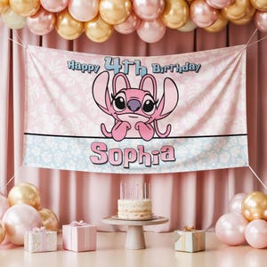 Op de afbeelding: Een roze banner met de tekst "Happy 4th Birthday Sophia" en een stripfiguur. De banner is versierd met een bloemenpatroon en hangt voor een roze gordijn. Ballonnen en een taart zijn ook zichtbaar.