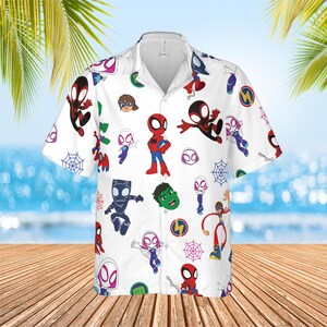 May include: A white short-sleeve button-down shirt featuring an all-over print of various cartoon superhero characters, including Spider-Man, Ghost-Spider, Black Panther, and Hulk, interspersed with small blue and pink spider web icons.