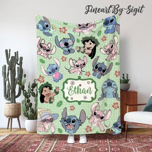 May include: A light green blanket featuring cartoon characters in various poses, with red and pink floral accents. The blanket has the name "Ethan" in a decorative frame. The blanket is made of a soft material.