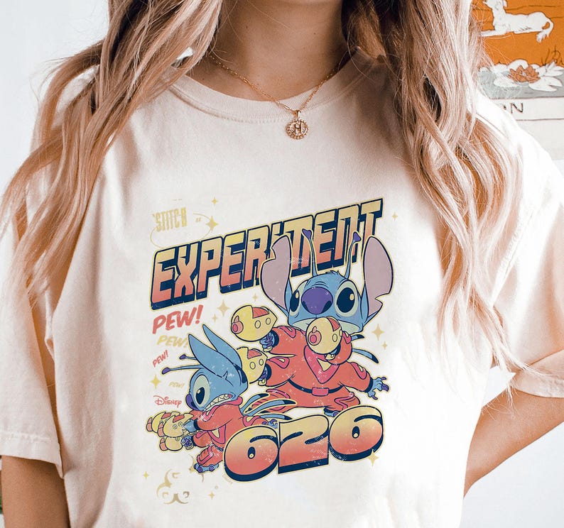 May include: A white t-shirt with a blue and red graphic of Stitch from Lilo & Stitch. The graphic says "Experiment 626" and "Pew!" in a retro font.