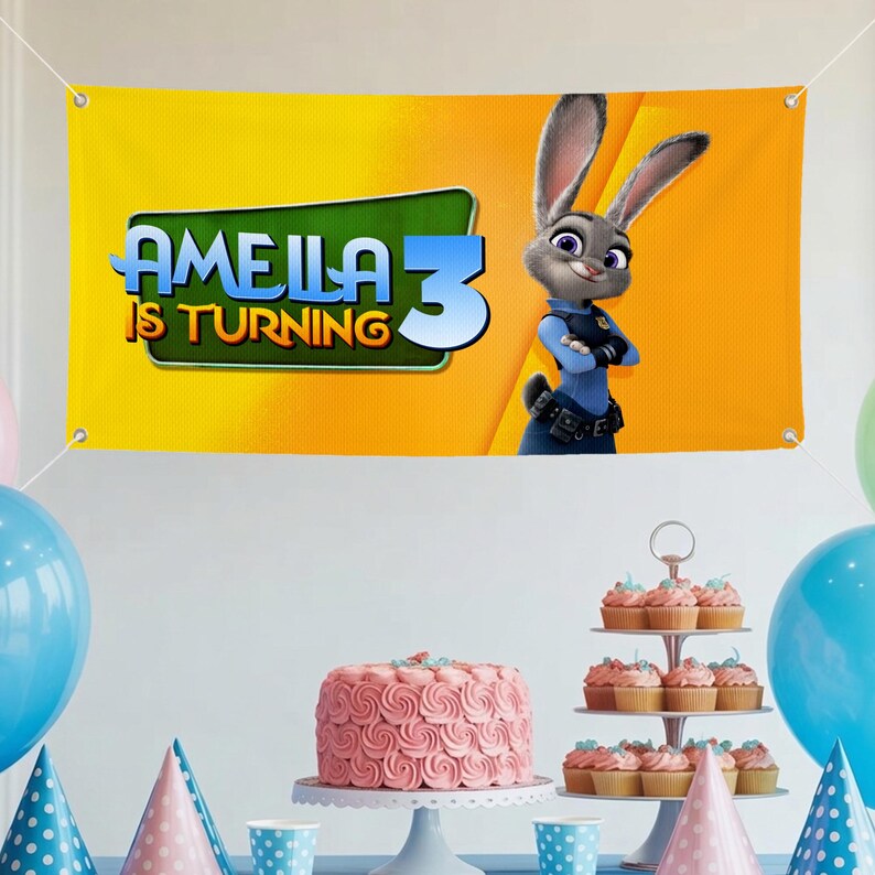 May include: A yellow banner with the text "AMEILA IS TURNING 3" and an image of a cartoon rabbit in a police uniform. The banner is hung above a table with a pink cake, cupcakes, and party hats.