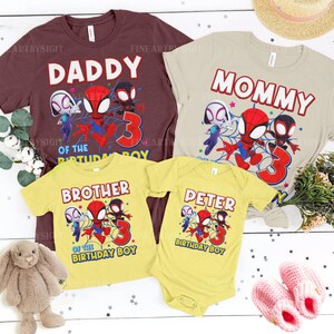 K&ouml;nnte beinhalten: Eine Sammlung passender Familien-Geburtstagsshirts mit Spider-Man-Charakteren. Die Shirts sind in Burgunderrot, Beige und Gelb gehalten und tragen die Aufschriften "Daddy", "Mommy", "Brother" und "Peter". Jedes Shirt hat die Zahl "3" und den Satz "of the birthday boy."