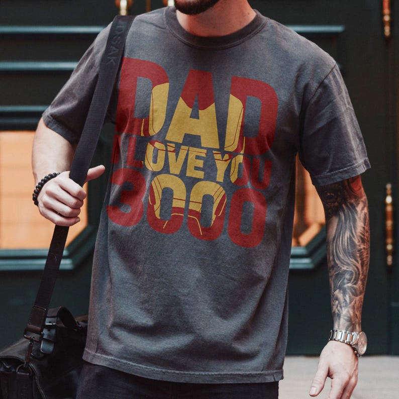 May include: A dark gray t-shirt with a red and yellow graphic print that says "DAD I LOVE YOU 3000".