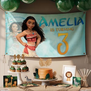 K&ouml;nnte beinhalten: Eine Geburtstagsparty-Szene mit einem Banner mit einer Zeichentrickfigur und dem Namen "Amelia" mit dem Text "is turning 3". Der Tisch umfasst einen Kuchen, Cupcakes und dekorative Gegenst&auml;nde mit Dschungel-Thema.