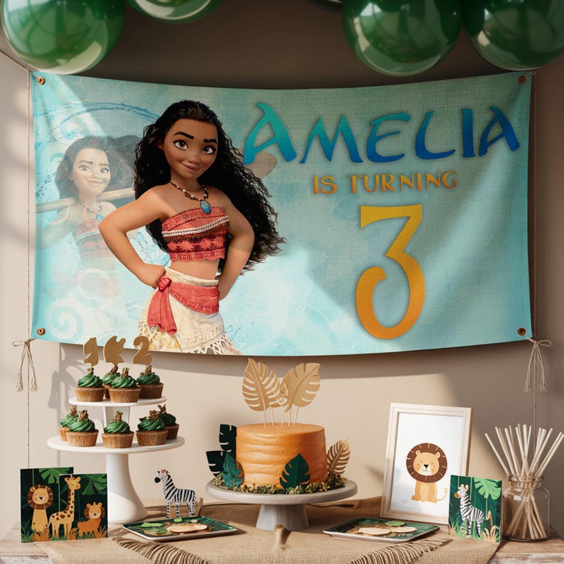 K&ouml;nnte beinhalten: Eine Geburtstagsparty-Szene mit einem Banner mit einer Zeichentrickfigur und dem Namen "Amelia" mit dem Text "is turning 3". Der Tisch umfasst einen Kuchen, Cupcakes und dekorative Gegenst&auml;nde mit Dschungel-Thema.
