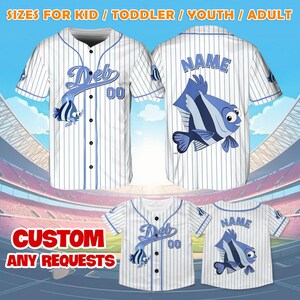 May include: White baseball jersey with blue stripes and a blue fish graphic. The jersey has a blue button-up front and says "Deb 00" on the front and "NAME" on the back. The jersey is available in sizes for kids, toddlers, youth, and adults.