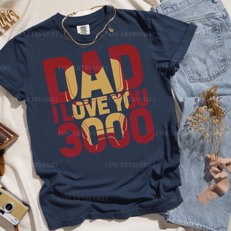 May include: A navy blue t-shirt with the text "Dad I Love You 3000" in red and yellow. The text is stylized to look like Iron Man's chest plate.