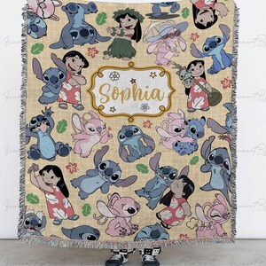 Puede incluir: Una manta beige con los personajes de dibujos animados Stitch y Lilo. La manta tiene una etiqueta personalizada con el nombre "Sophia". La manta tiene un borde con flecos. La URL de la tienda Etsy est&aacute; en la parte inferior.