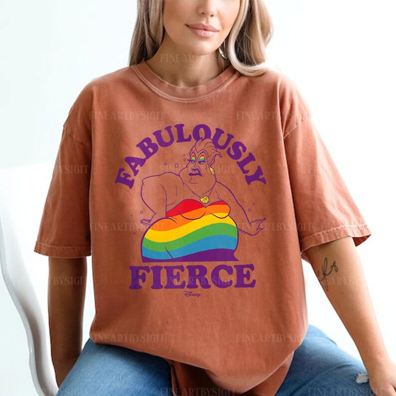 Peut inclure: T-shirt de couleur rouille avec une illustration de personnage de dessin anim&eacute; et le texte "FABULOUSLY FIERCE" en violet. Le personnage est repr&eacute;sent&eacute; avec un motif aux couleurs de l'arc-en-ciel. Le logo Disney est en bas.