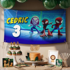 May include: A birthday party banner with the name "Cedric" and the number "3" in large white letters. The banner features cartoon characters. A cake, cupcakes, and other decorations are on a table in front of the banner.