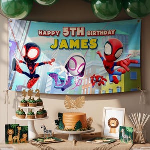 May include: A birthday party scene with a banner that reads "Happy 5th Birthday James" featuring Spider-Man characters. The table includes cupcakes, a cake, and animal-themed decorations. Green balloons are visible.