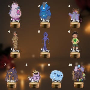 May include: Ten acrylic character standees featuring various animated figures, including aliens, robots, and humans. Each figure is mounted on a circular wooden base with the word Name printed in white text below the character illustration.
