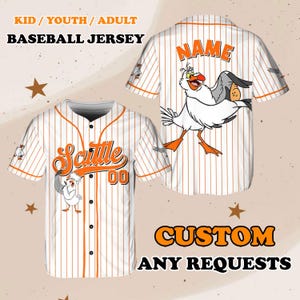 May include: White and orange baseball jersey with a cartoon seagull graphic and the text "Scuttle 00" on the front. The back of the jersey has the text "NAME" on it. The jersey is available in kid, youth, and adult sizes.