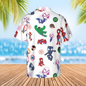 May include: A white short-sleeve button-down shirt featuring an all-over print of various cartoon superhero characters including Spider-Man, Ghost-Spider, Hulk, and Black Panther, interspersed with red spider web icons and green fist symbols.