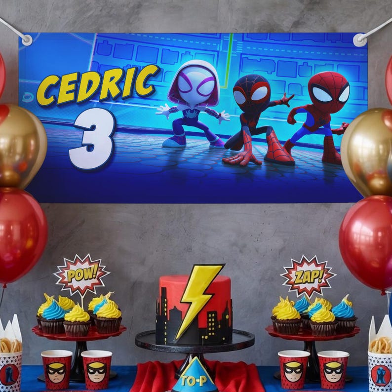 May include: A birthday party scene with a banner that says "CEDRIC 3" and features cartoon Spider-Man characters. The table is decorated with a cake, cupcakes, and superhero-themed cups and decorations. Red and gold balloons are also present.