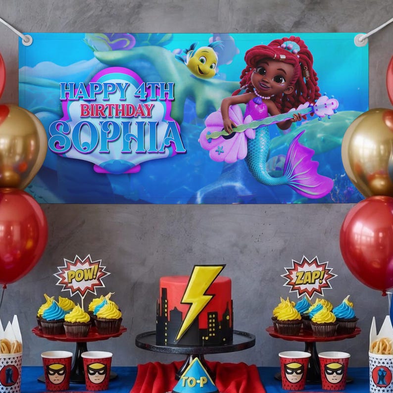K&ouml;nnte beinhalten: Eine Geburtstagsparty-Szene mit einem Banner mit der Aufschrift "Happy 4th Birthday Sophia". Das Banner zeigt eine Meerjungfrau, die Gitarre spielt. Die Party beinhaltet einen Kuchen mit Blitzdesign, Cupcakes, Luftballons und Tassen im Superhelden-Stil.