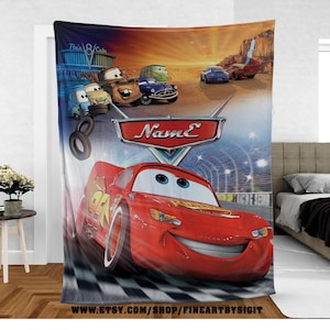 May include: A plush blanket featuring Lightning McQueen from the animated movie Cars. The blanket showcases a vibrant scene with the character on a checkered race track, with other characters and a desert backdrop. The blanket has the text "Name" on it.