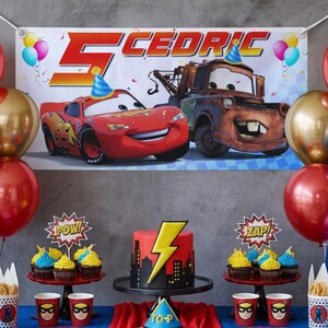 May include: A birthday party scene featuring a banner with the name "Cedric" and the number "5", along with cartoon cars. The table is decorated with a cake, cupcakes, and superhero-themed cups. Balloons in red and gold add to the festive atmosphere.
