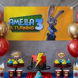 May include: A birthday party scene with a banner that reads "Amelia is Turning 3" and features a cartoon rabbit. A red and black cake with a lightning bolt design sits on a black stand. Cupcakes, balloons, and themed cups complete the festive decor.