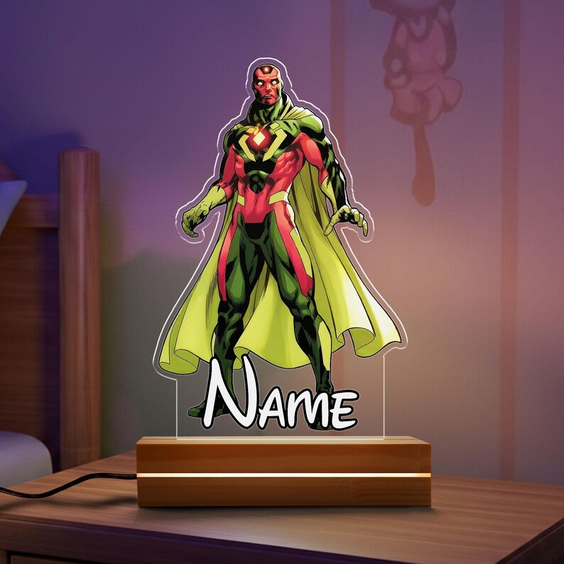 May include: A Vision character night light with a wooden base. The superhero is depicted in a red, green, and yellow costume, standing in a heroic pose. The word "Name" is written in a bold font at the base of the character.